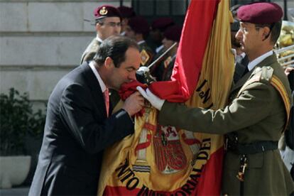 El ministro de Defensa, José Bono, acompañado por la cúpula militar, besa la bandera en un acto militar de despedida.