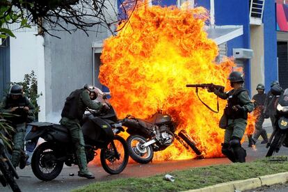 Fuerzas de seguridad antidisturbios se enfrentan a manifestantes, mientras una motocicleta se incendia durante una protesta contra el gobierno del presidente venezolano, Nicolás Maduro, en San Cristóbal, Venezuela.