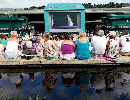 Un grupo de aficionados siguen la semifinal en una pantalla gigante instalada en la colina de Henman, fuera de las pistas de Wimbledon.
