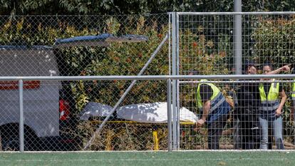 Miembros del retén fúnebre trasladan esta mañana del viernes el cadáver del menor de unos 11 años que desapareció este jueves cuando se bañaba en el río Júcar, a su paso por la localidad valenciana de Alzira.