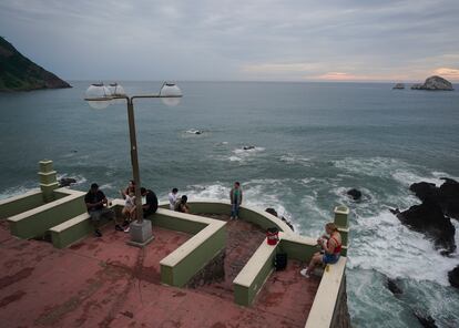 Personas toman fotos frente al mar en un mirador de Mazatlán.