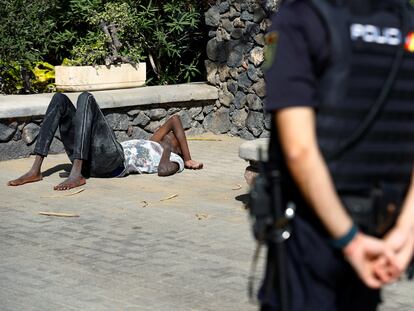 Un hombre yace en el suelo tras llegar en patera a la playa de Maspalomas, en el sur de Gran Canaria el pasado 1 de noviembre.
