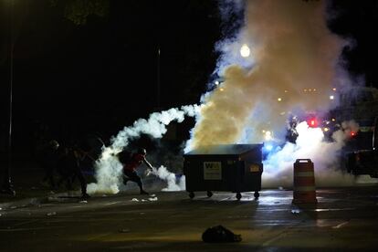 Un manifestante arroja una lata de humo, en la tercera noche de protestas tras el tiroteo a Jacob Blake, en Kenosha (Wisconsin, Estados Unidos).