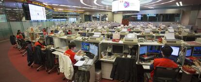 Corredores de bolsa observan las transacciones realizadas en la bolsa de Hong Kong.