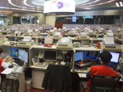 Corredores de bolsa observan las transacciones realizadas en la bolsa de Hong Kong.