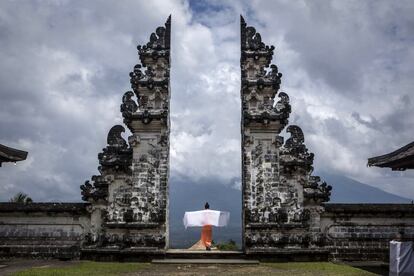 Un turista extiende un mantón en la puerta del tempo Penataran Agung Lempuyang en Bali, Indonesia.