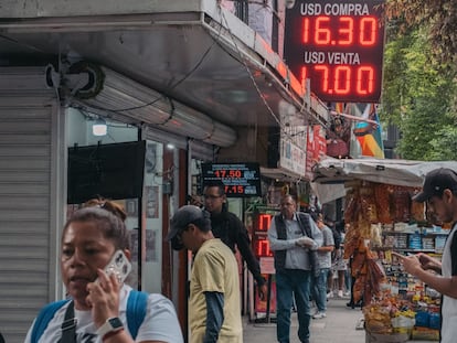 Personas caminan afuera de una casa de cambio en Ciudad de México, en julio.