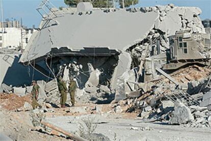Soldados israelíes, junto a uno de los edificios de la <i>Mukata</i> derruidos.