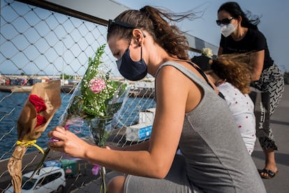 Varias personas colocan flores este viernes en el muelle de Santa Cruz de Tenerife como ofrendas en memoria de Anna y Olivia.