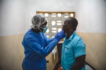 Sierra Leona atraviesa un nuevo brote de ‘mpox’ (antes viruela del mono, un nombre que la OMS desaconseja porque estigmatiza), una enfermedad que en enero de este año fue declarada como emergencia de salud pública por el ministerio de Salud local. Los 16 distritos del país han registrado casos, y los de la zona occidental, incluida la capital Freetown, han sido identificados como focos del brote.
"La ‘mpox’ no es nueva en Sierra Leona. Esta es la cuarta vez que registramos casos. El brote actual está afectando principalmente al distrito del Área Rural del Oeste y a la capital, que son zonas densamente pobladas con más de un millón de habitantes", explica Agnes Dama, referente de Médicos Sin Fronteras para la respuesta de ‘mpox’ en Sierra Leona y encargada de coordinar las actividades médicas de la organización relacionadas con el brote en el país.
Según la Agencia Nacional de Salud Pública (NPHA por sus siglas en inglés), hasta el 10 de julio se habían registrado 4.599 casos confirmados en el país y 33 muertes.
En la imagen, George Kamara, responsable de salud comunitaria de MSF, examina a un paciente en el centro de tratamiento de ‘mpox’ en Calaba Town, un vecindario de la capital.