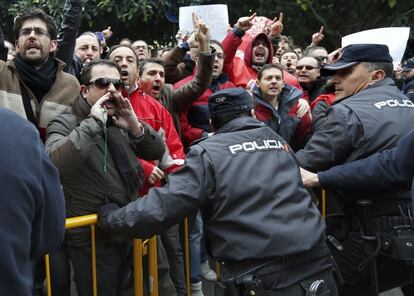 Los trabajadores de RTVV tras la valla colocada por la policía.