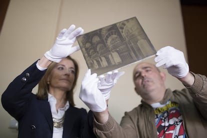 Ana Verdú y el fotógrafo y comisario de la muestra, Antonio Jesús González, muestran uno de los cristales que servían de negativos al fotógrafo.