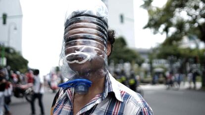 A falta de mascarilla, un hombre se protege de la covid-19 con una pantalla realizada con un bidón de plástico en San José, Costa rica, el 27 de julio de 2020. Este ciudadano participaba en una manifestación convocada por diversos grupos sindicales y sociales en contra de las medidas económicas aplicadas por el Gobierno durante la pandemia y para exigir un fondo de emergencia que auxilie a los desempleados.