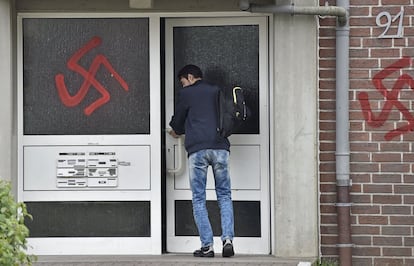 Un joven entra a un centro para refugiados pintado con símbolos nazis en Waltrop (Alemania). La policía alemana investiga los nuevos casos de ataques y acoso de la ultraderecha contra albergues de refugiados registrados en distintos puntos del este y del sur de Alemania, mientras siguen llegando miles de peticiones de asilo.