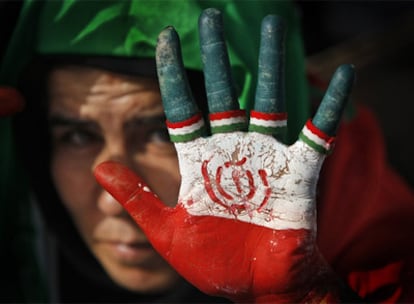 Una partidaria del presidente Ahmadineyad muestra su mano pintada con la bandera iraní durante el mitin de fin de campaña.