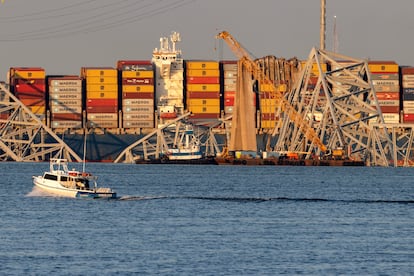 A large crane is positioned beside the cargo vessel 'Dali' seen with toppled sections of the Francis Scott Key Bridge, in Baltimore, Maryland, March 29, 2024.