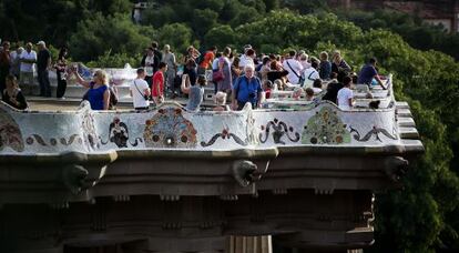 Visitants del Park Güell ocupen el banc de trencadis.