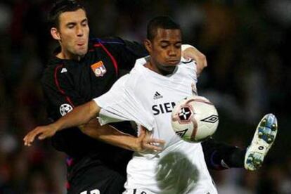 Robinho intenta llevarse el balón ante Reveillere.