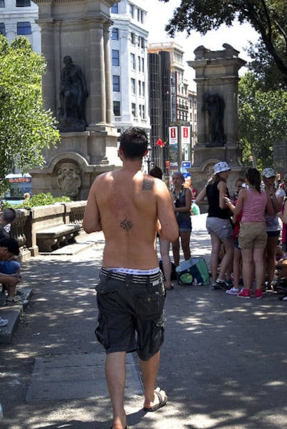 Un joven sin camiseta, ayer en la plaza de Catalunya.