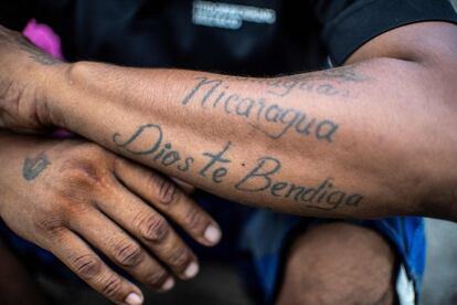 Un hombre fotografiado en la estación de tren de Ciudad Hidalgo (México) luce un tatuaje que dice "Nicaragua, Dios te bendiga". 
