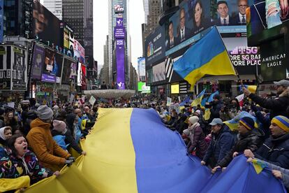 Manifestantes despliegan una gran bandera de Ucrania en Times Square de Nueva York (EE UU).