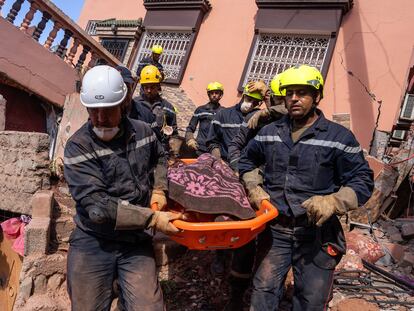 OUIRGANE, MOROCCO - SEPTEMBER 10: Emergency workers carry the body of a woman after finding her beneath a collapsed building on September 10, 2023 in Ouirgane, Morocco. A huge earthquake measuring 6.8 on the Richter scale has hit central Morocco. Whilst the epicentre was in a sparsely populated area of the High Atlas Mountains, the effects have been felt 71km away in Marrakesh, a major tourist destination,  where many buildings have collapsed and hundreds of deaths reported. (Photo by Carl Court/Getty Images)