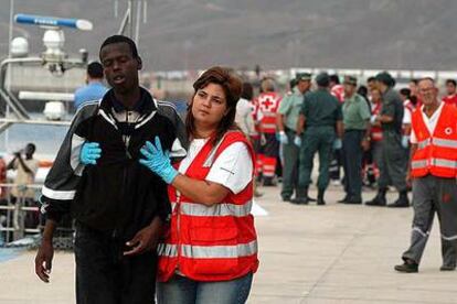Uno de los 17 inmigrantes rescatados ayer en Fuerteventura es asistido por una enfermera de Cruz Roja.
