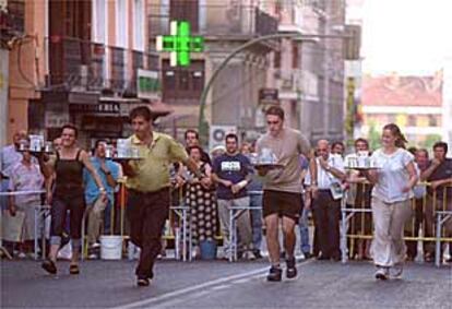 Algunos de los participantes en la carrera de camareros en la calle de Toledo.