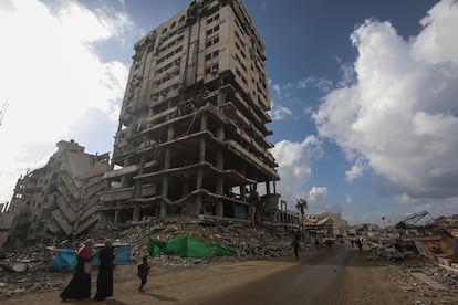 Palestinos caminan junto a edificios destruidos en la Ciudad de Gaza, este mircoles.