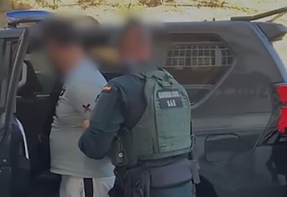 Un agente de la Guardia Civil ayuda a subir al vehculo al arrestado por crear y difundir material yihadista desde Mlaga.