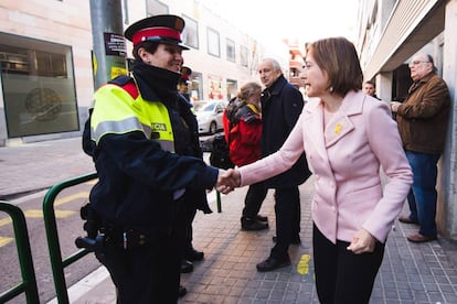 Carme Forcadell saluda a un 'mosso d'esquadra' antes de votar en Sabadell (Barcelona).