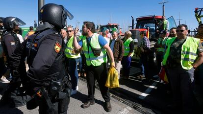 Un manifestante se dirige a los agentes de Policía Nacional en Córdoba, durante la protesta de agricultores llegados desde distintos puntos de la provincia, este martes.