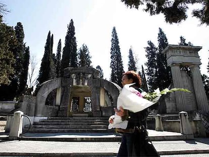 Una mujer lleva flores al Cementerio Civil de Madrid.