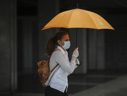 Una mujer se resguarda de la lluvia el pasado día 15 en Sevilla.