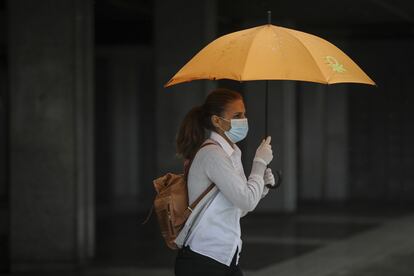 Una mujer se resguarda de la lluvia el pasado día 15 en Sevilla.