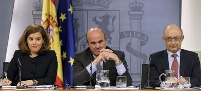 La vicepresidenta del Gobierno, Soraya Sáenz de Santamaría, junto a los ministros de Economía, Luis de Guindos; y de Hacienda, Cristóbal Montoro.