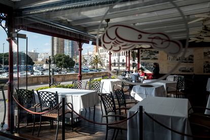 Una camarera atiende la mesa de unos clientes en un restaurante del puerto de Palamós.