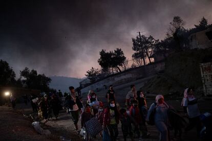 En la imagen, refugiados y migrantes huyen del segundo incendio. 