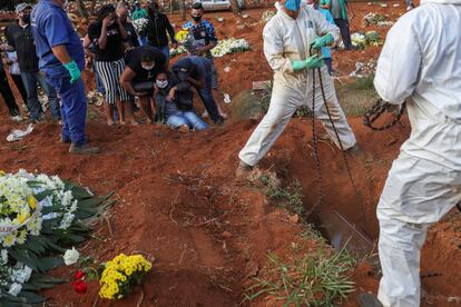 Familiares de Geraldo Magalhães, morto por coronavírus, choram durante o enterro em Vila Formosa, o maior cemitério do Brasil, em São Paulo, em 22 de maio.