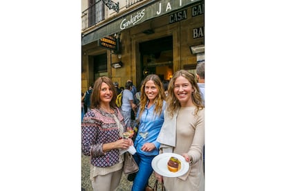 Tres mujeres muestran un pincho a la puerta del bar Gandarias.