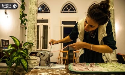 A member of the EatWith website prepares food for guests.