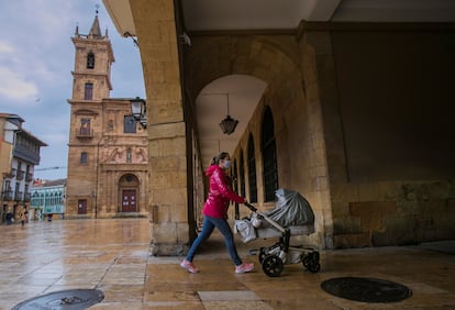 Una mujer pasea a su hija recién nacida en la plaza del ayuntamiento de Oviedo, en mayo de 2020. 