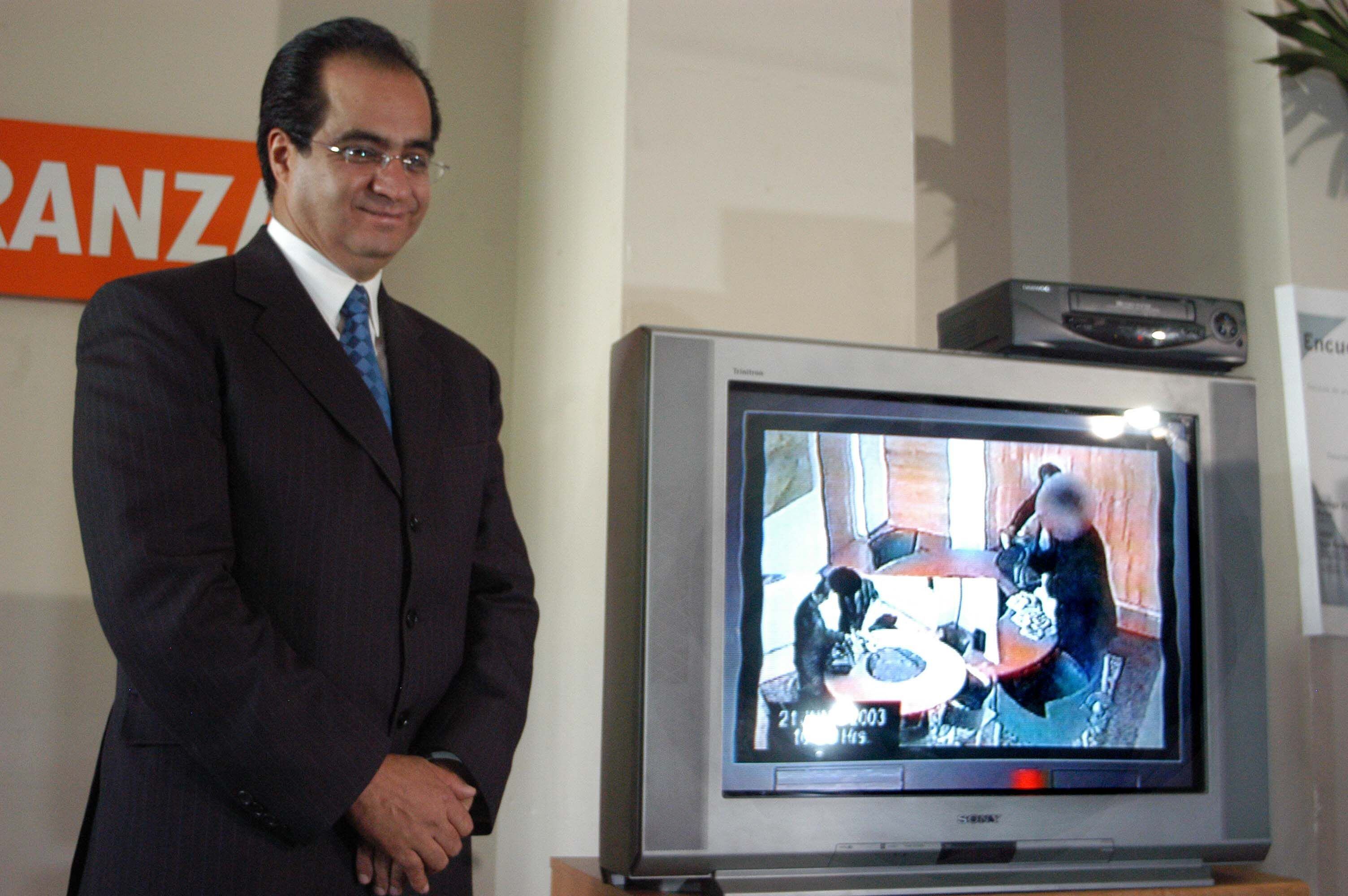 René Bejarano muestra en un televisor la forma en que fue editado el video donde se muestra que recibe dinero del empresario Carlos Ahumada, en abril de 2004.