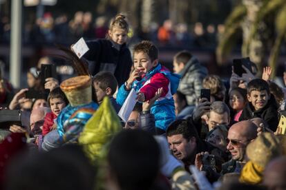 Un niño entrega su carta a un paje del rey Baltasar antes de la cabalgata en Barcelona.