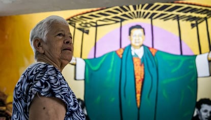 La religiosa Maritze Trigos frente a un mural con la imagen del párroco Tiberio Fernández, en el parque monumento en homenaje a las víctimas de la masacre de Trujillo.