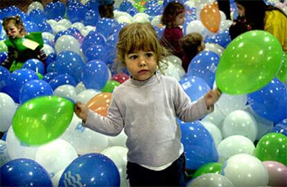 Una niña jugaba ayer con un montón de globos en uno de los pabellones de la feria Expojove, en Valencia.