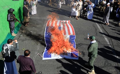 Partidarios de los rebeldes hutíes queman una pancarta que representa las banderas de Estados Unidos e Israel durante una protesta en la capital de Yemen, Saná. EFE/EPA/YAHYA ARHAB