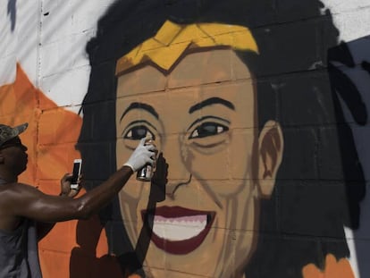 O grafiteiro Aria Crespo pinta um mural com a imagem da vereadora do PSOL Marielle Franco