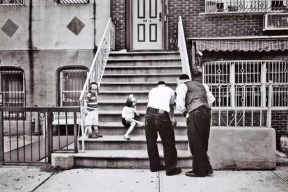 Otra escena de dos hombres y dos niños ante la entrada de una casa en el barrio judío de Brooklyn.