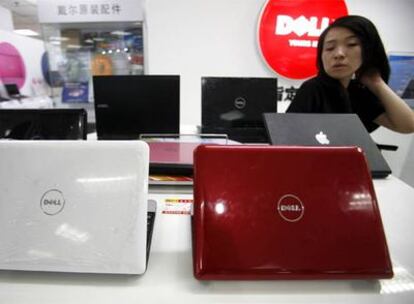 Una vendedora  muestra varios modelos de computadoras de Dell en una feria celebrada en junio pasado en Pekín.